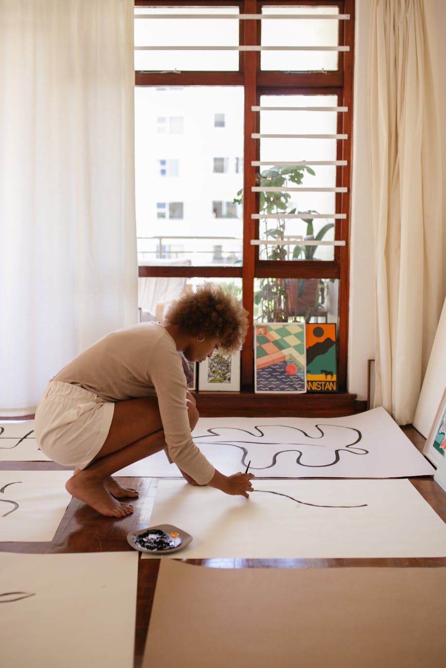photo of woman drawing on white canvass